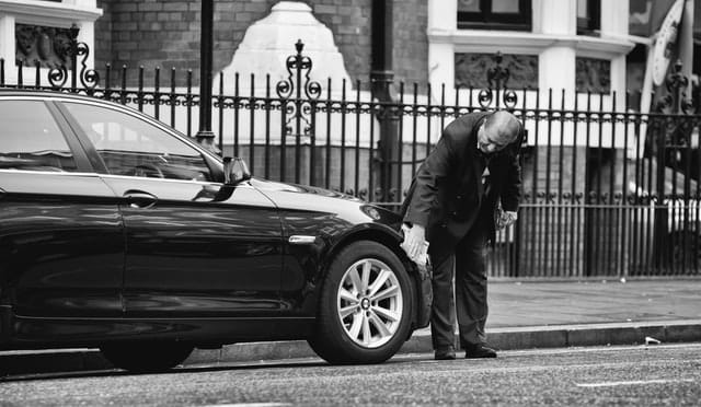 a man standing on the road. he has paid for rental car insurance